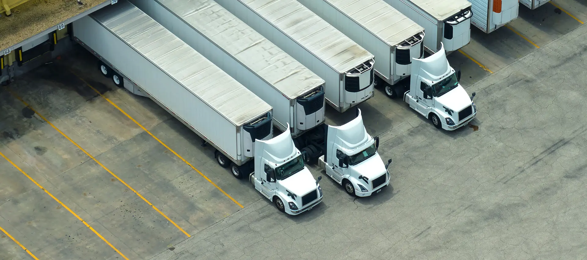 Vista de una flota de camiones estacionados en un aparcamiento, que muestra la necesidad de un mantenimiento adecuado y de herramientas de apriete precisas.