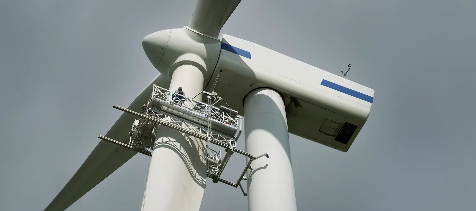 Un técnico de servicio de campo trabajando en una turbina eólica.