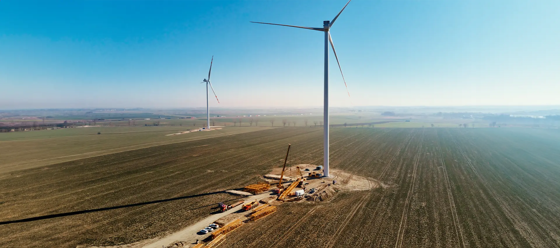 Un aerogenerador en fase de construcción o mantenimiento en un campo.